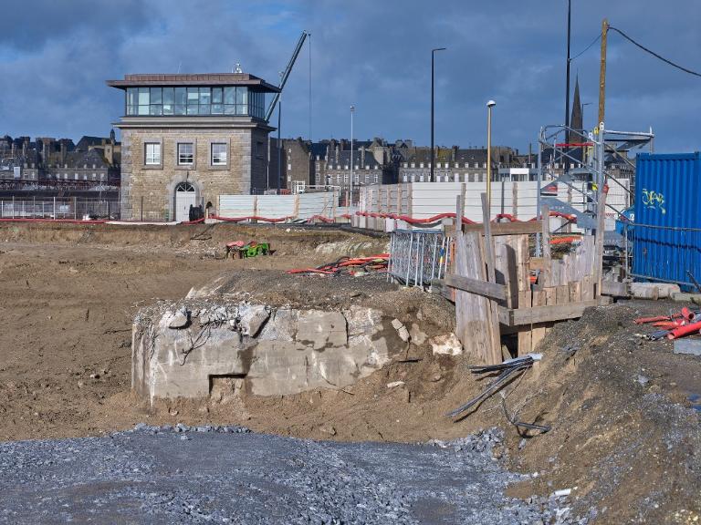 Vue générale depuis le sud-est (couverture photographique du 22 janvier 2026). La partie en saillie à gauche correspond au poste d'observation. Les planches masquent l'une des deux entrées du bunker. En arrière-plan, poste de commande de l'écluse du Naye
